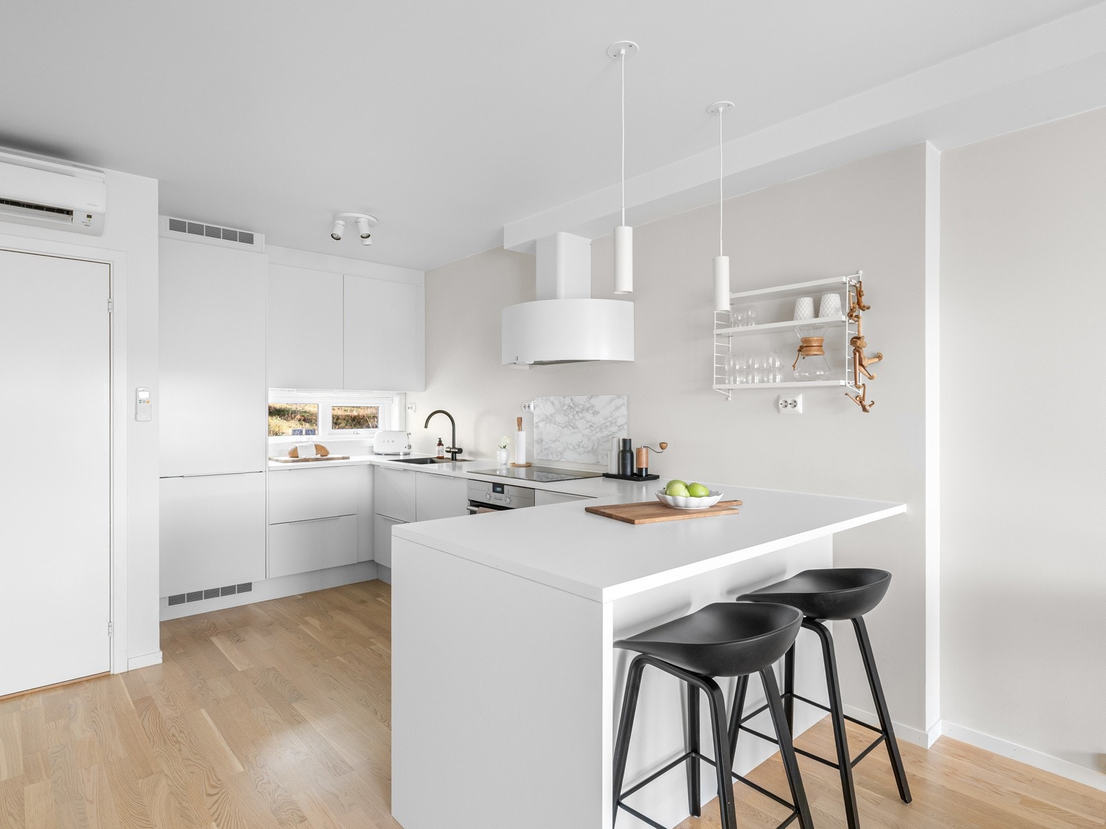 En barløsning med plass til barstoler gir en uformell spiseplass og gjør kjøkkenet til et naturlig samlingspunkt i boligen. Galleribilde