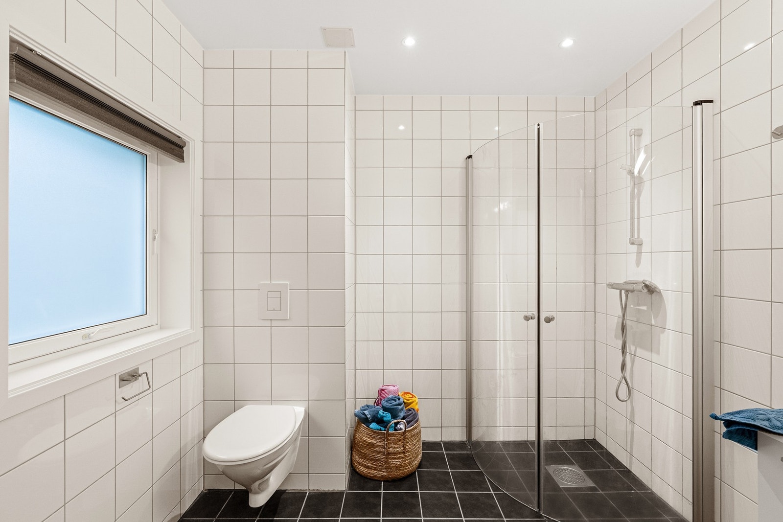 Pent bad med flislagt gulv med gulvvarme og flislagte vegger. Galleribilde