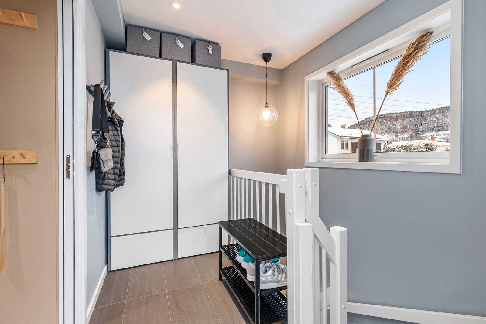 Entré med flislagt gulv og garderobeskap Galleribilde