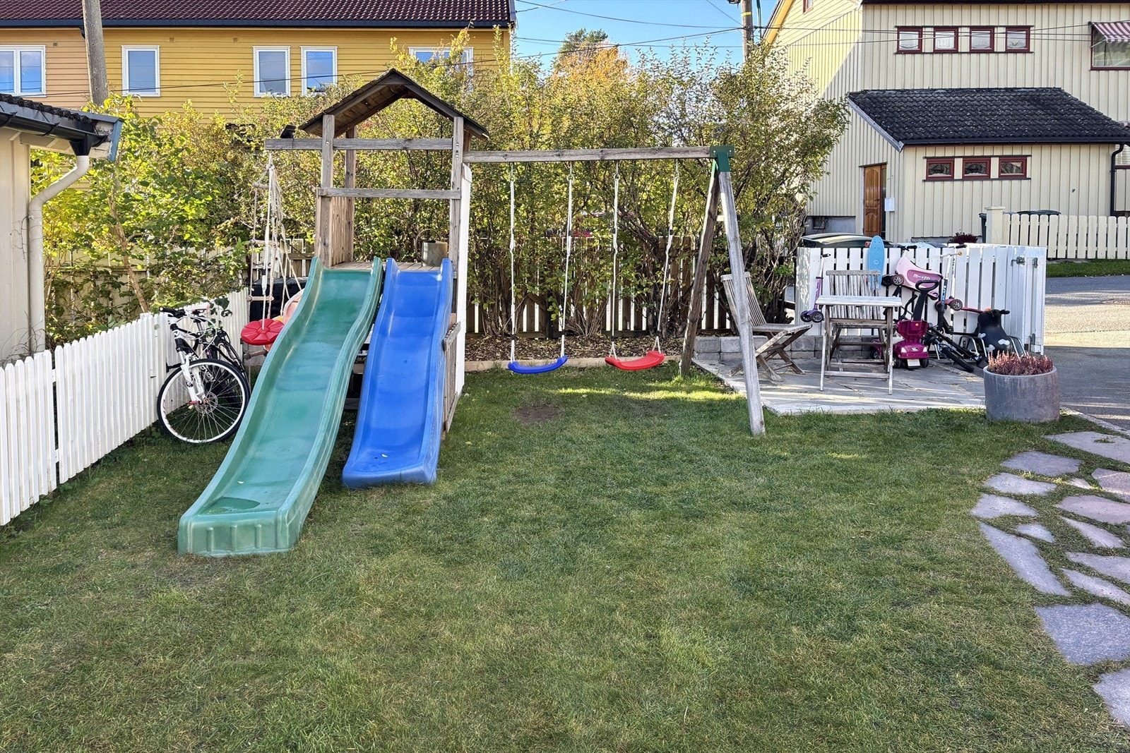 Hellelagt plass ved siden av lekestativet, her kan de voksne drikke morgenkaffen mens barna leker i hagen Galleribilde