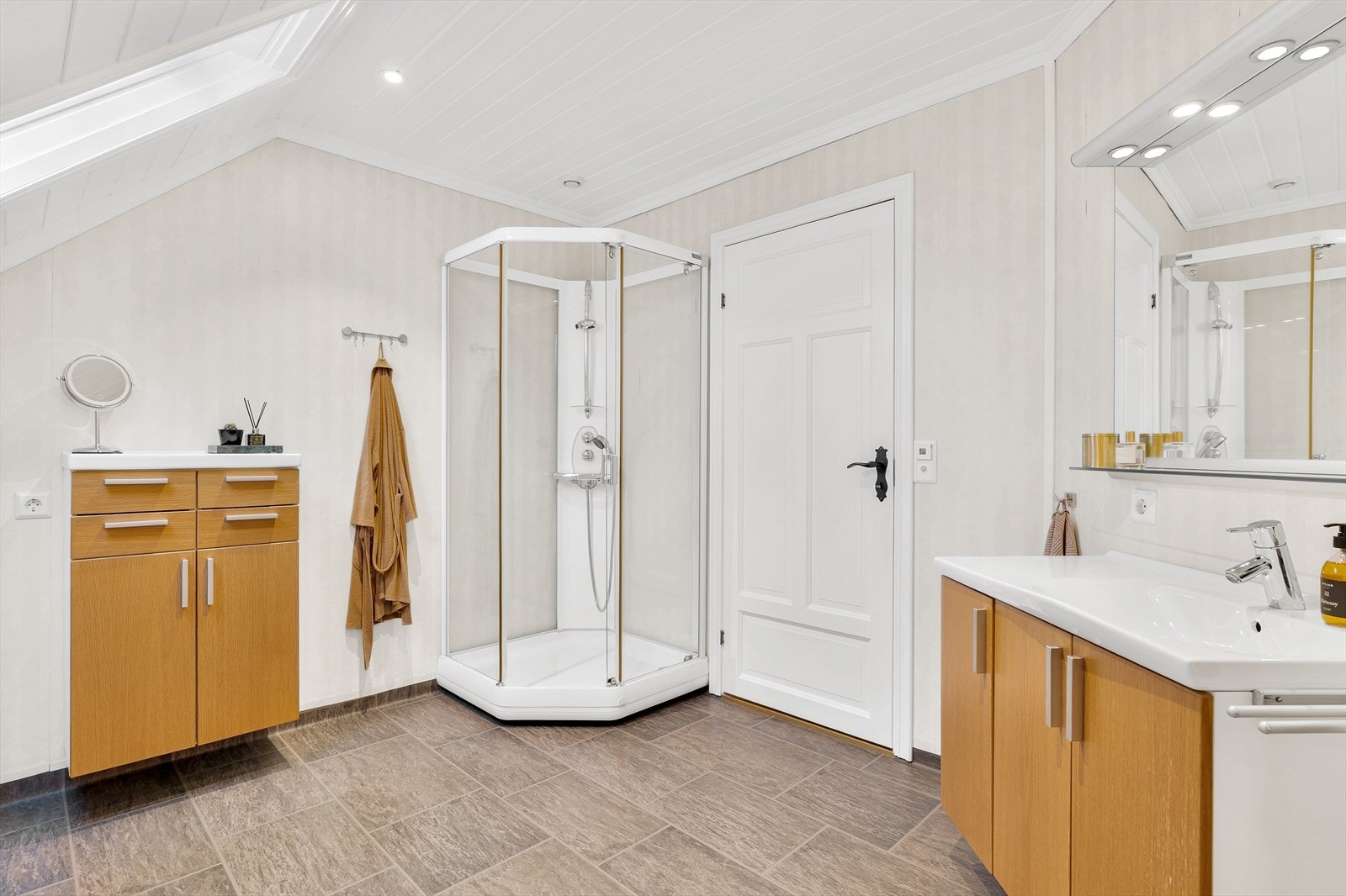 Rommet er innredet med dusjkabinett, badekar, nedfelt servant, skap og toalett Galleribilde