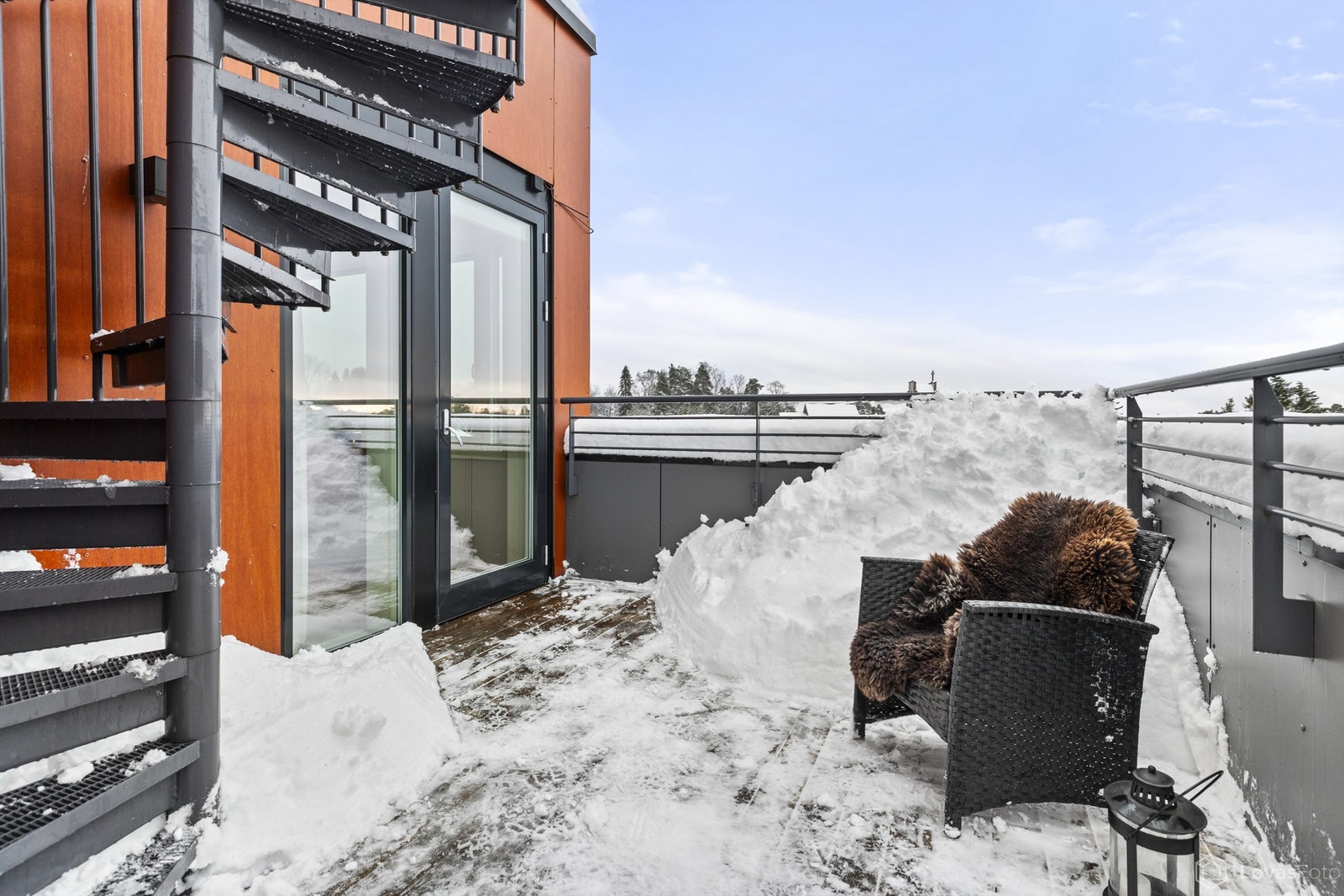 En vindeltrapp i metall leder fra terrassen opp til den private takterrassen. Galleribilde