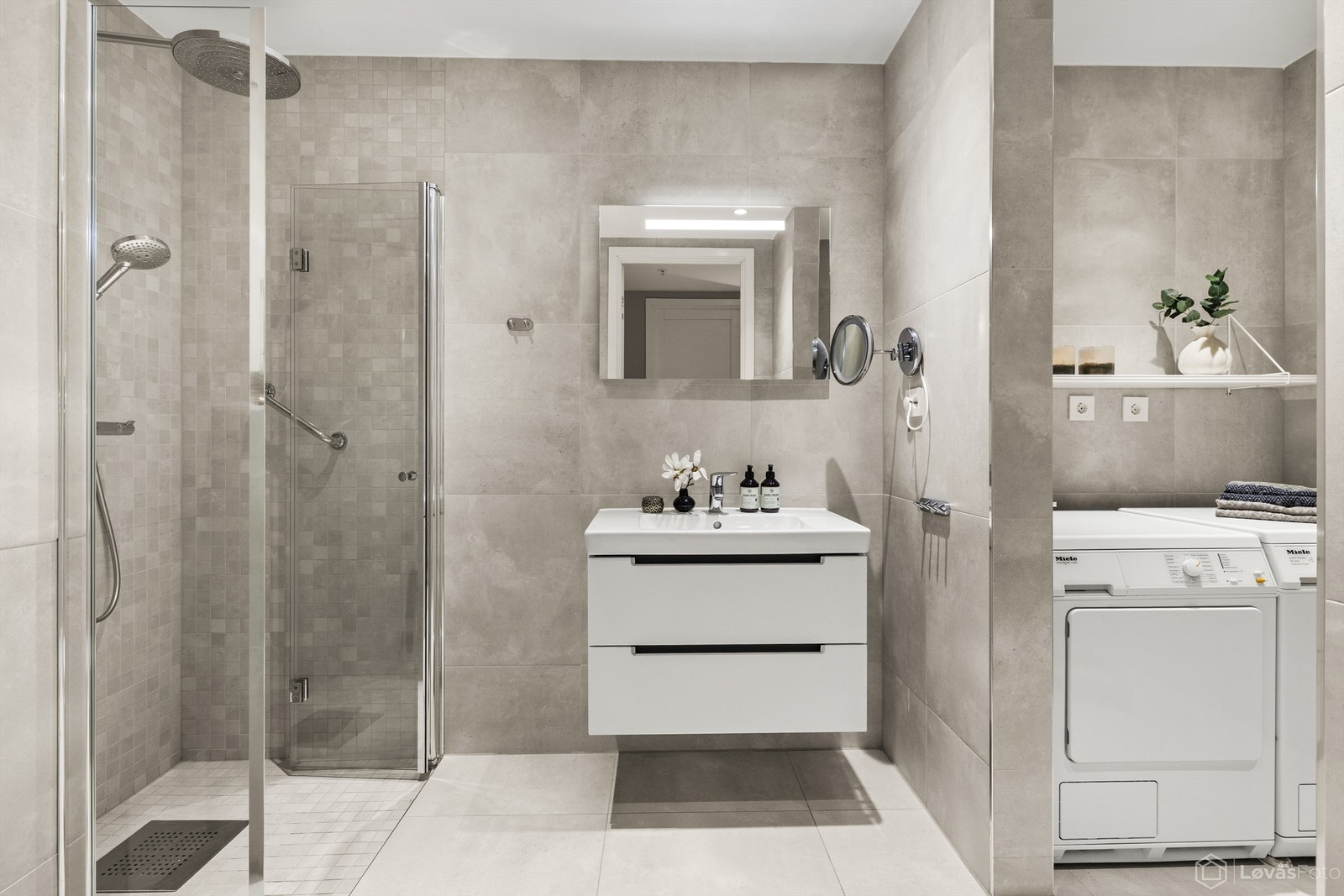 Leilighetens hovedbad er flislagt og har vegghengt innredning og toalett. Praktisk dusjnisje med svingbare dører. Galleribilde