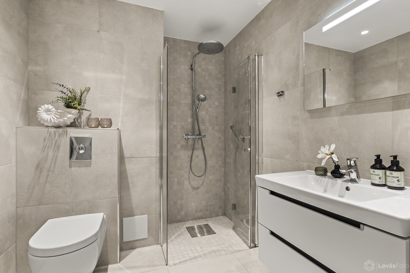 På hovedbadet er det bred innredning med heldekkende servant med ett-greps armatur. Galleribilde