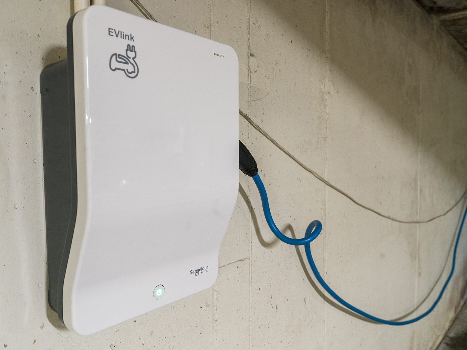 Ladestasjon for el-bil montert ved garasjeplassen. Galleribilde