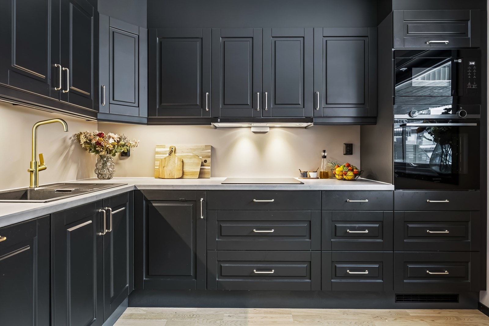 Kjøkkenet har et stilfullt uttrykk med tidsmessige fargevalg og integrerte hvitevarer. Galleribilde