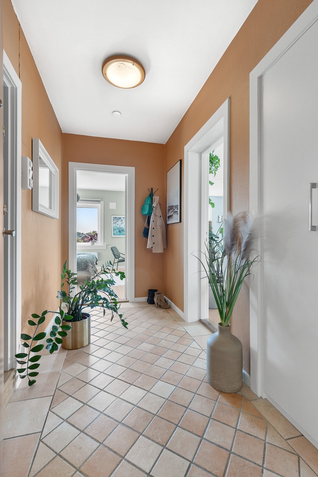 Innbydende entrè med flislagt gulv. Her er det god plass til å henge fra seg yttertøy og sette fra seg sko. Galleribilde