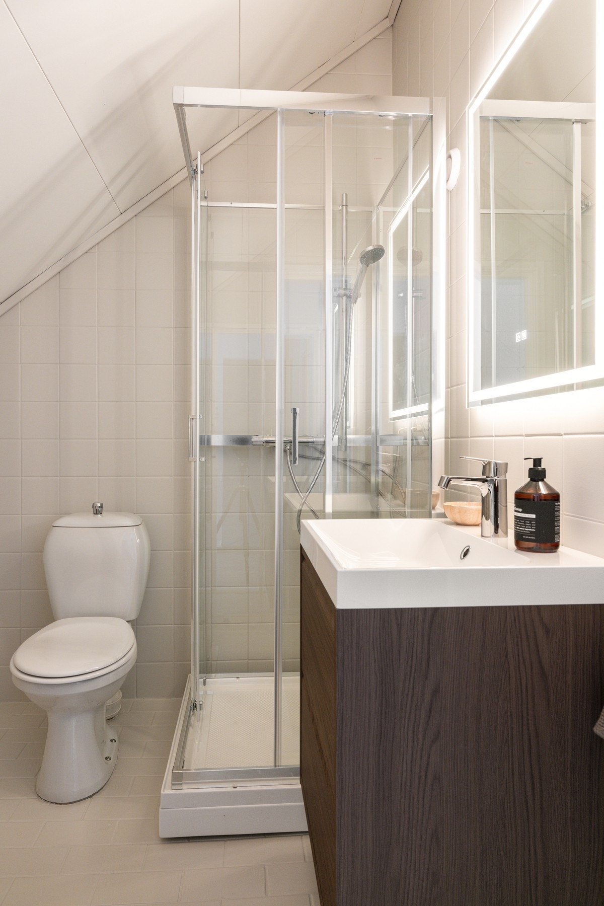 Ny og moderne badromsinnredning, speil med lys og nytt dusjkabinett. Galleribilde