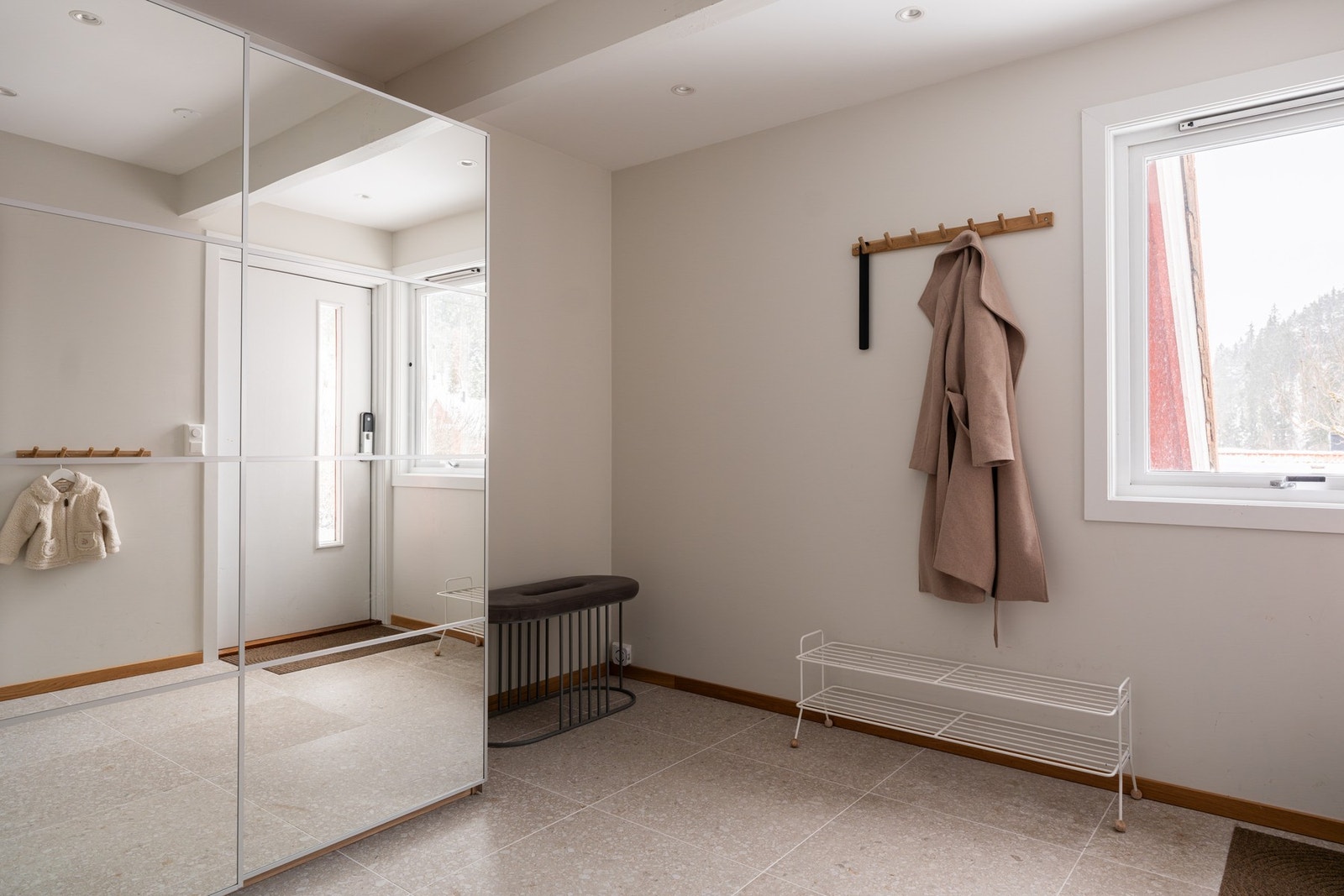 Stor og innbydende entré/hall med flislagt gulv med varmekabler. Det er installert Yale Doorman på entrédøren. Galleribilde