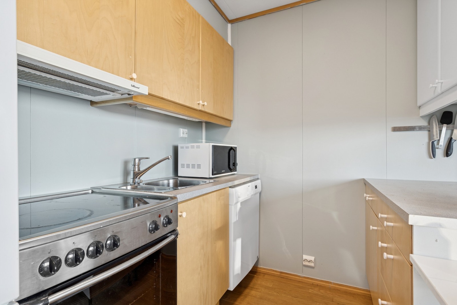 Kjøkkenet er innredet med: mekanisk avtrekksvifte over stekesonen og opplegg for oppvaskmaskin komfyr og kjøleskap. Galleribilde