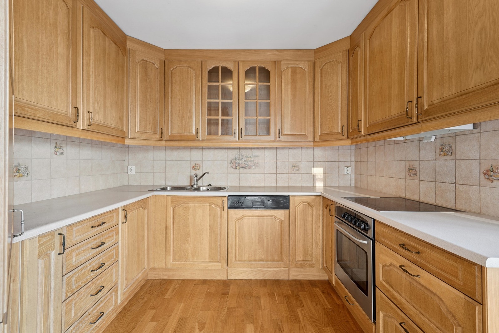 Romslig kjøkken innredet med mekanisk avtrekksvifte over stekesone. Galleribilde