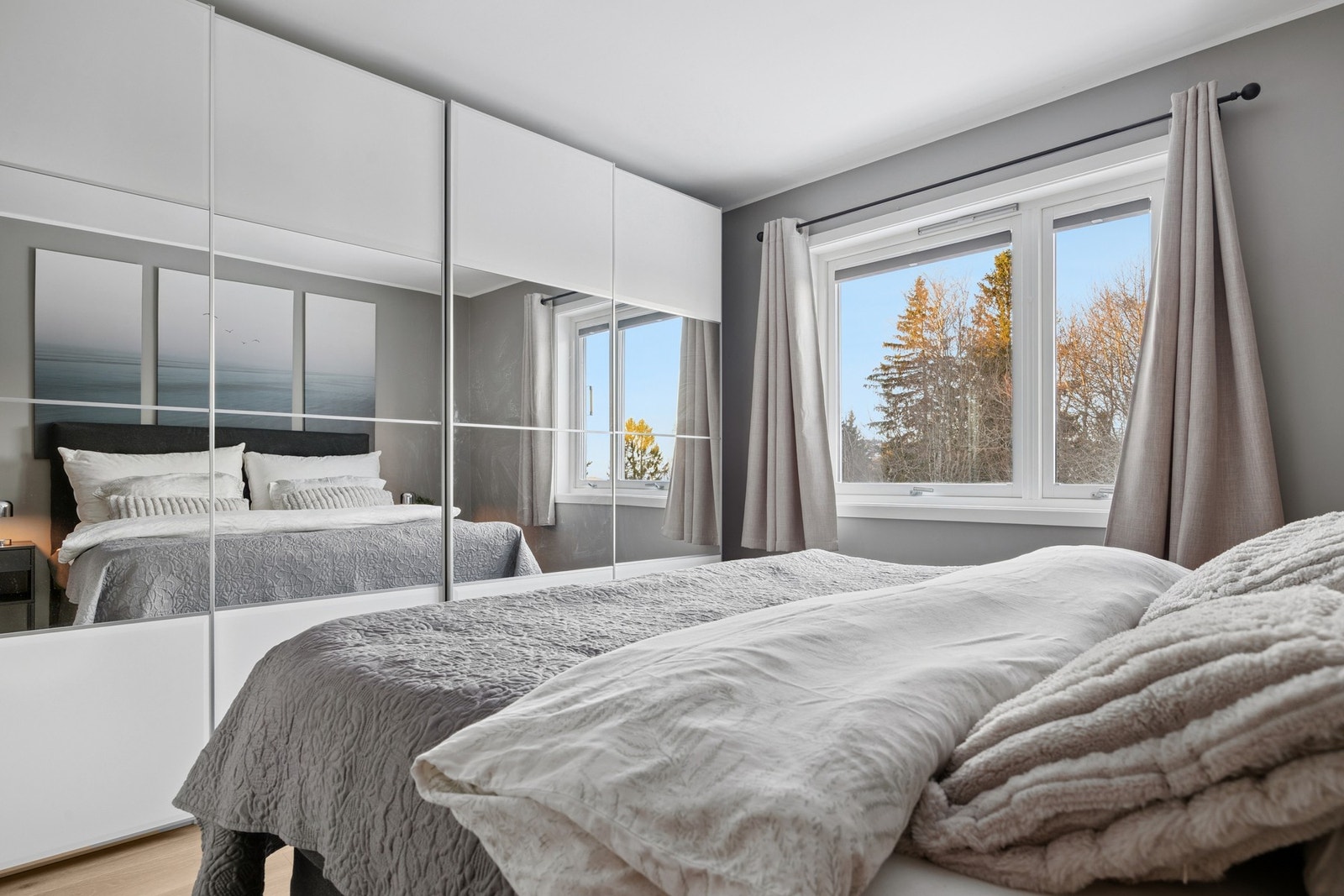 Romslig garderobeskap med speilfronter og skyvedører - både praktisk og stilfullt. Galleribilde