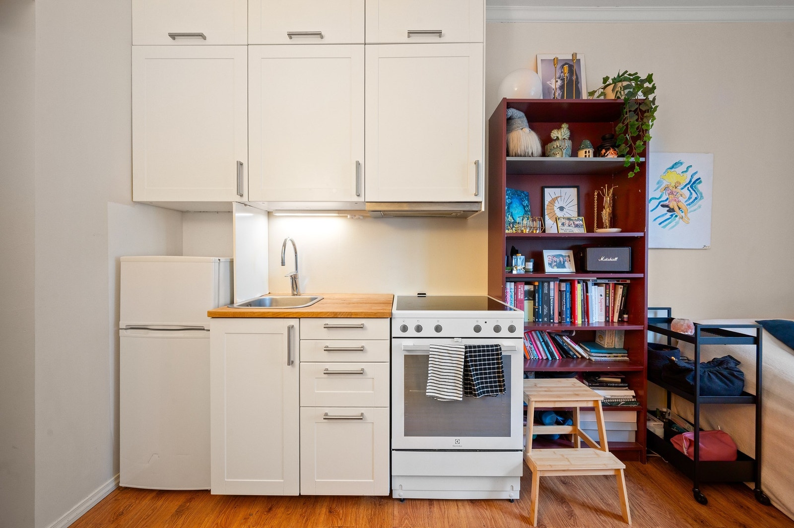 Her finner du et funksjonelt kjøkken med hvite, glatte fronter og benkeplate i heltre med kontaktplast. Galleribilde