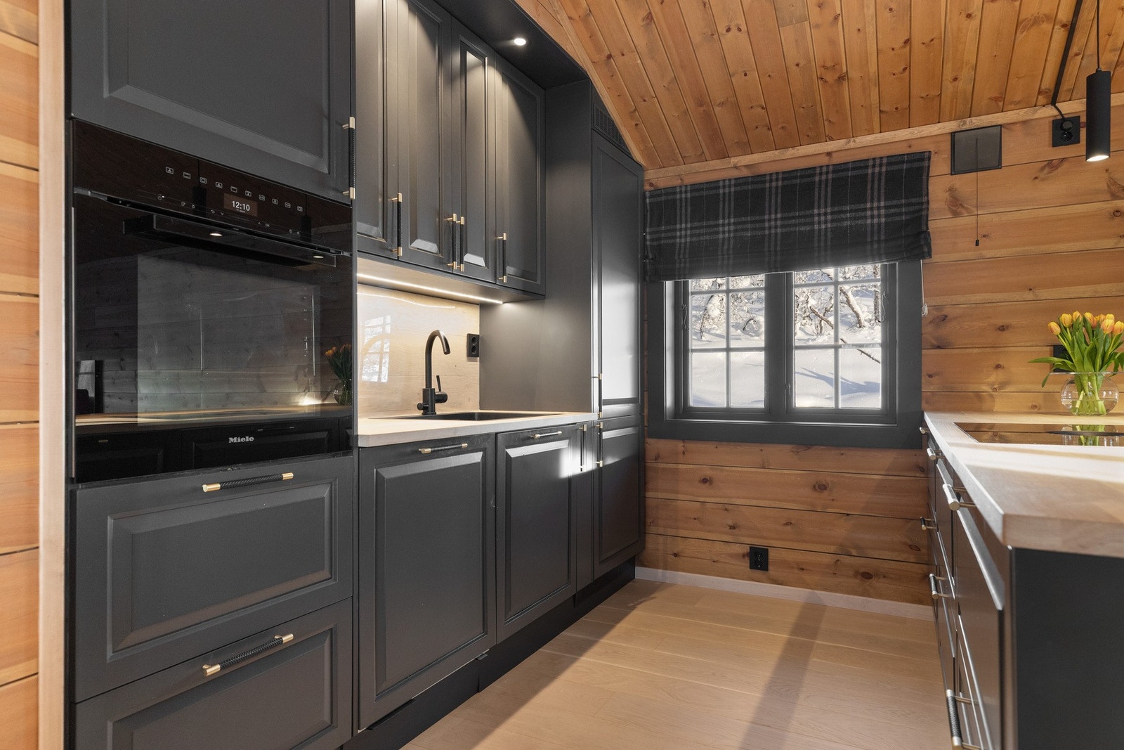 Kjøkkeninnredningen er i malte plater med over-og underskap, heltre benkeplate og oppvaskkum av kompositt med kran av stål. Galleribilde