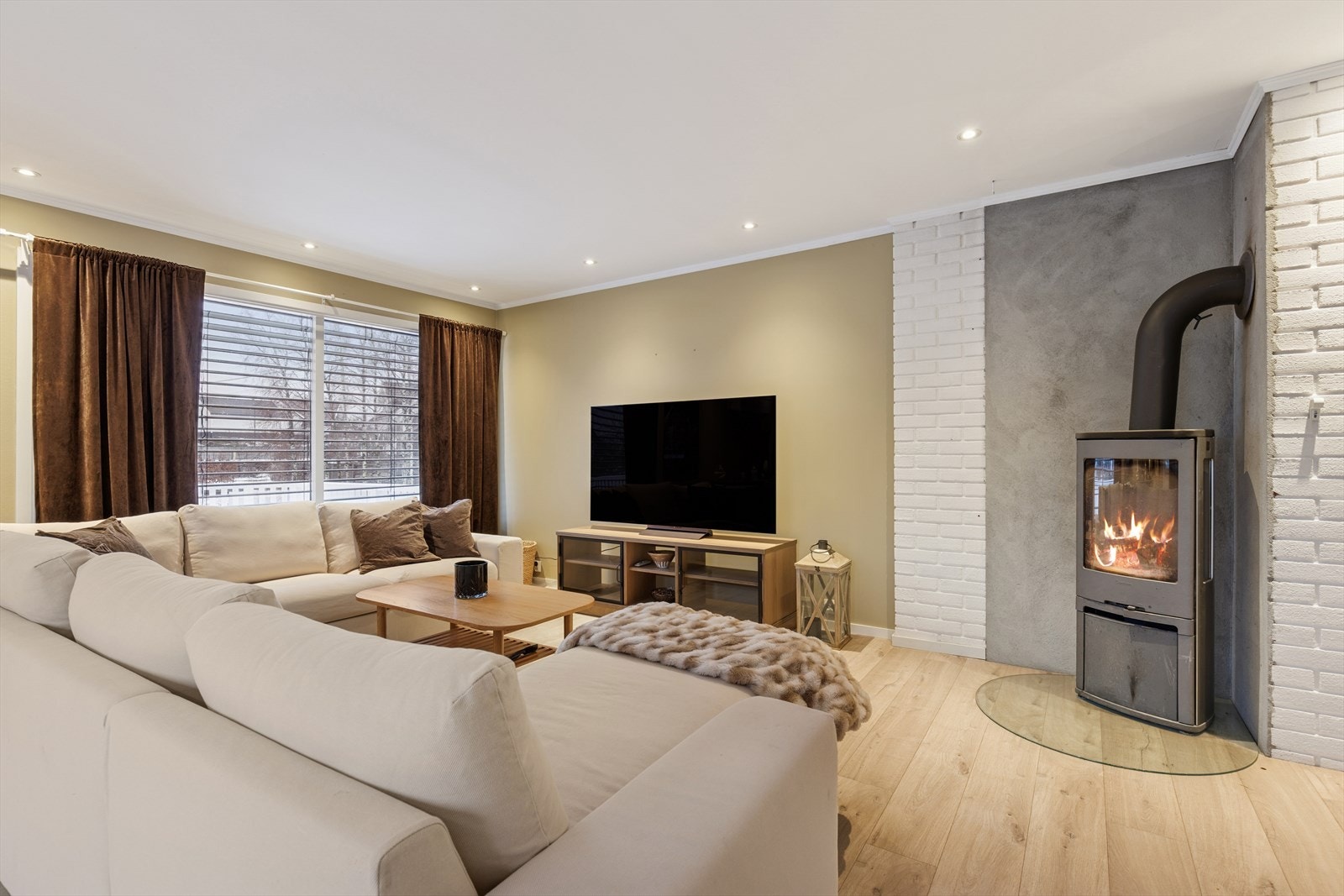 Stuen har både peisovn som skaper lun stemning og ekstra varme, i tillegg til varmepumpe som sørger for effektiv oppvarming. Galleribilde