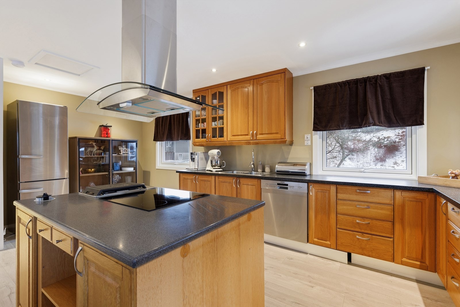 Innredningen har profilerte fronter og benkeplate utstyrt med oppvaskkum og kjøkkenkran. Enkelte overskap har fronter i glass. Galleribilde