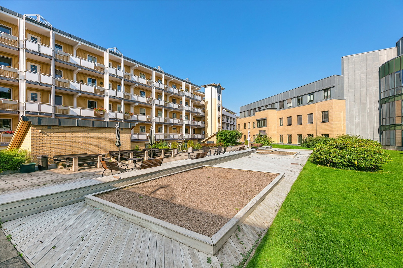 Mellom bebyggelsen er det et hyggelig tun med sitteplasser og lekeapparater for barn Galleribilde