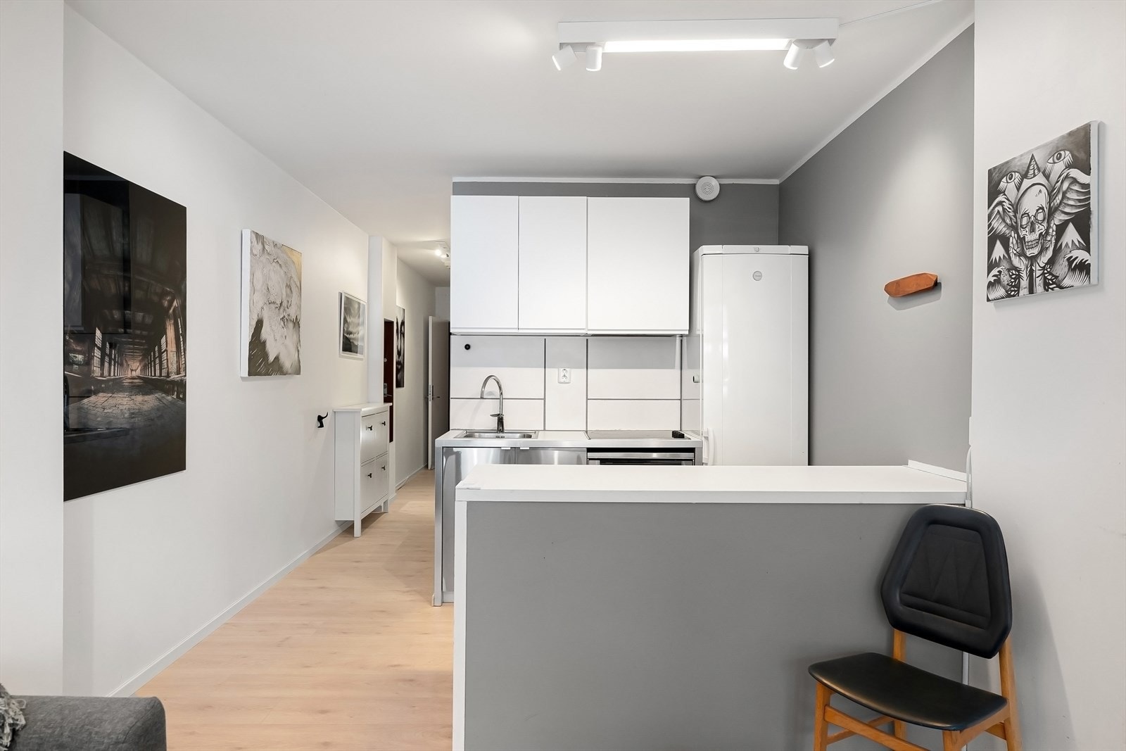 Kjøkken fra 2006 med slette fronter, fliser på vegg, laminat benkeplate og kjøkkenøy i tilsvarende utførelse. Utstyrt med kulfiltervifte. Galleribilde