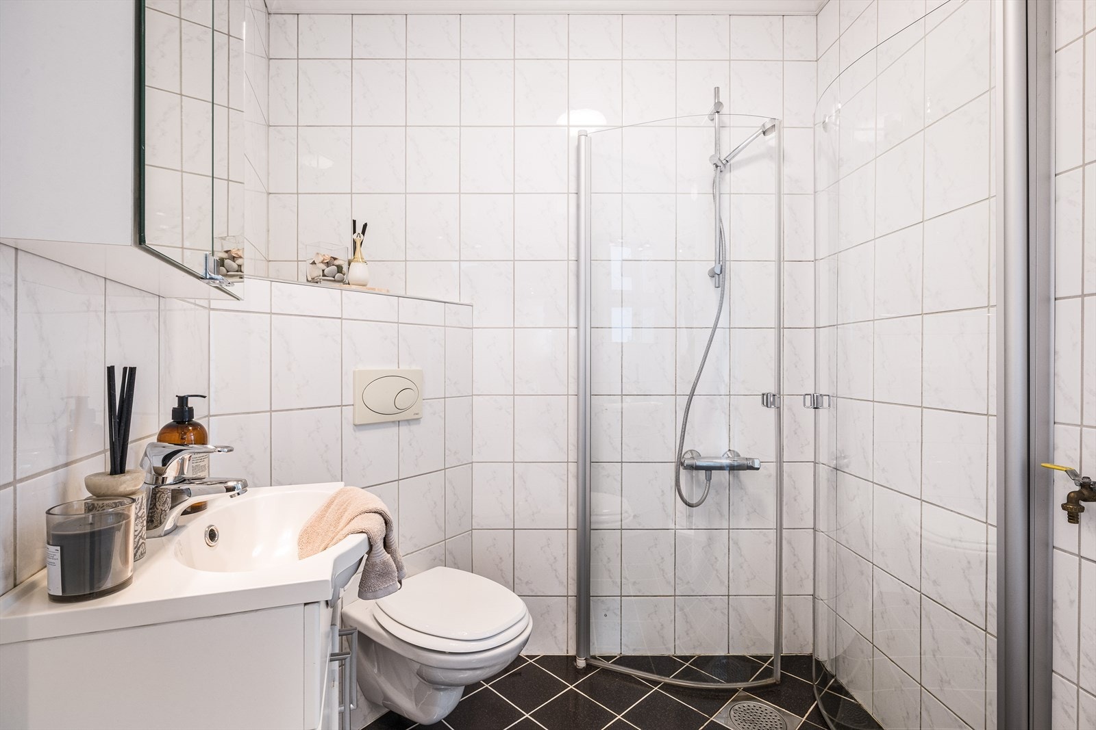 Pent og romslig helfliset bad/vaskerom med keramiske fliser på både gulv og vegger. Galleribilde