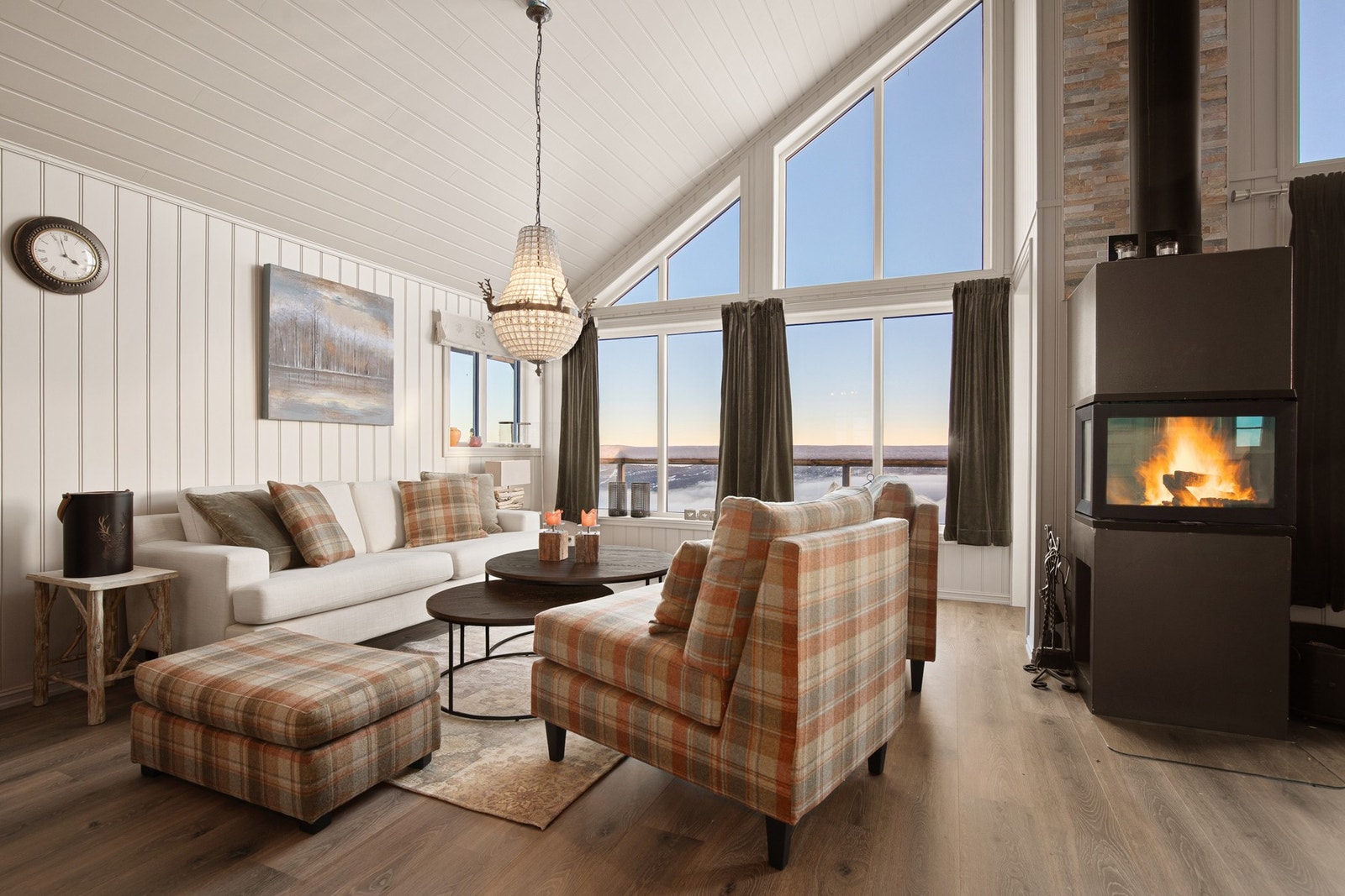 Stuen oppleves som lys og trivelig og samtidig lun med fin peisovn Galleribilde