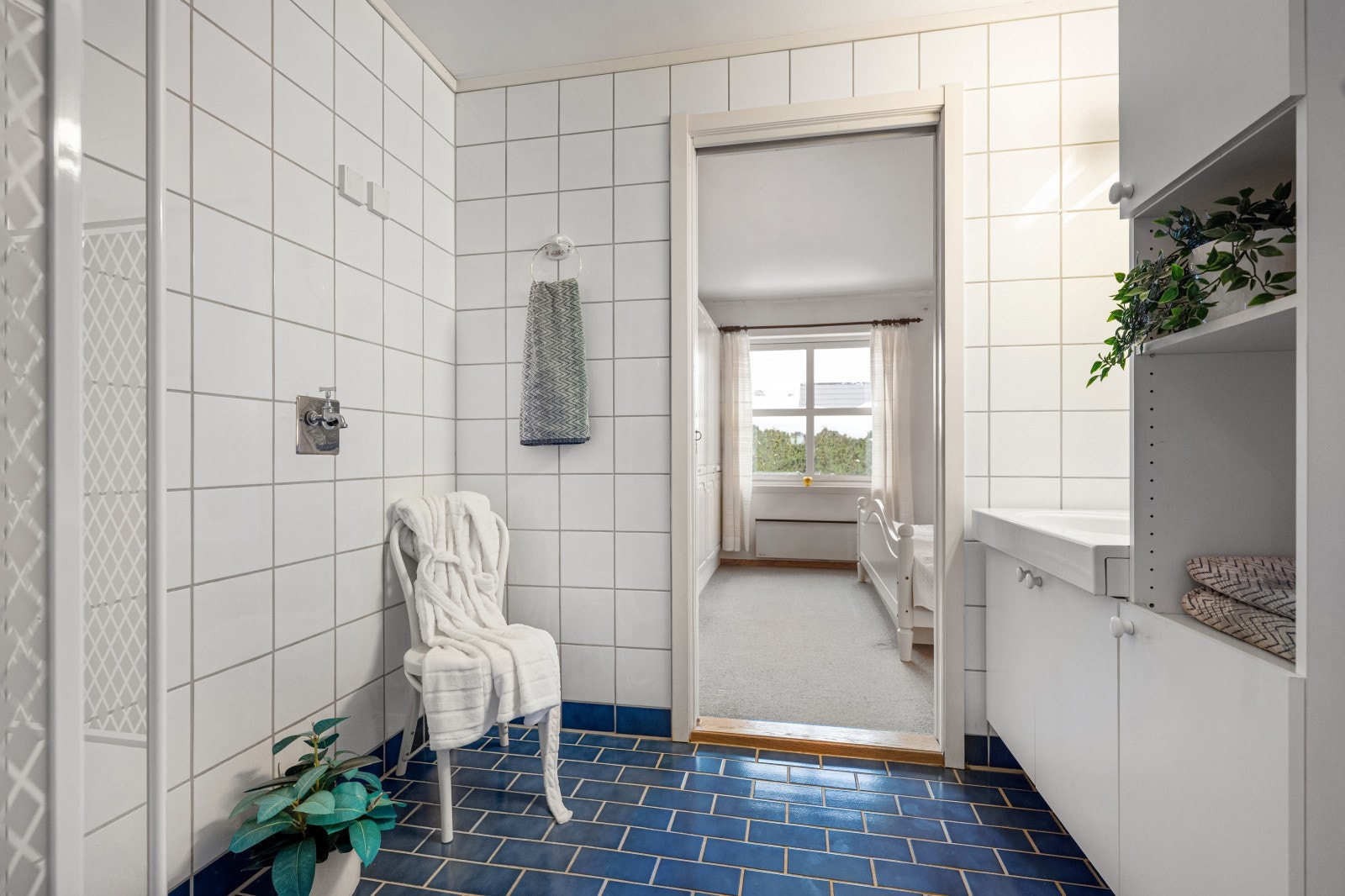 Det er dusjhjørne med dusjvegger og praktisk opplegg for vaskemaskin. Galleribilde