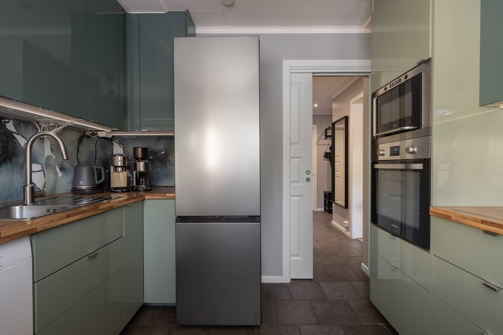 Rommet er utstyrt med induksjonstopp, integrert stekeovn og mikrobølgeovn, samt et frittstående kjøl/fryseskap. Galleribilde