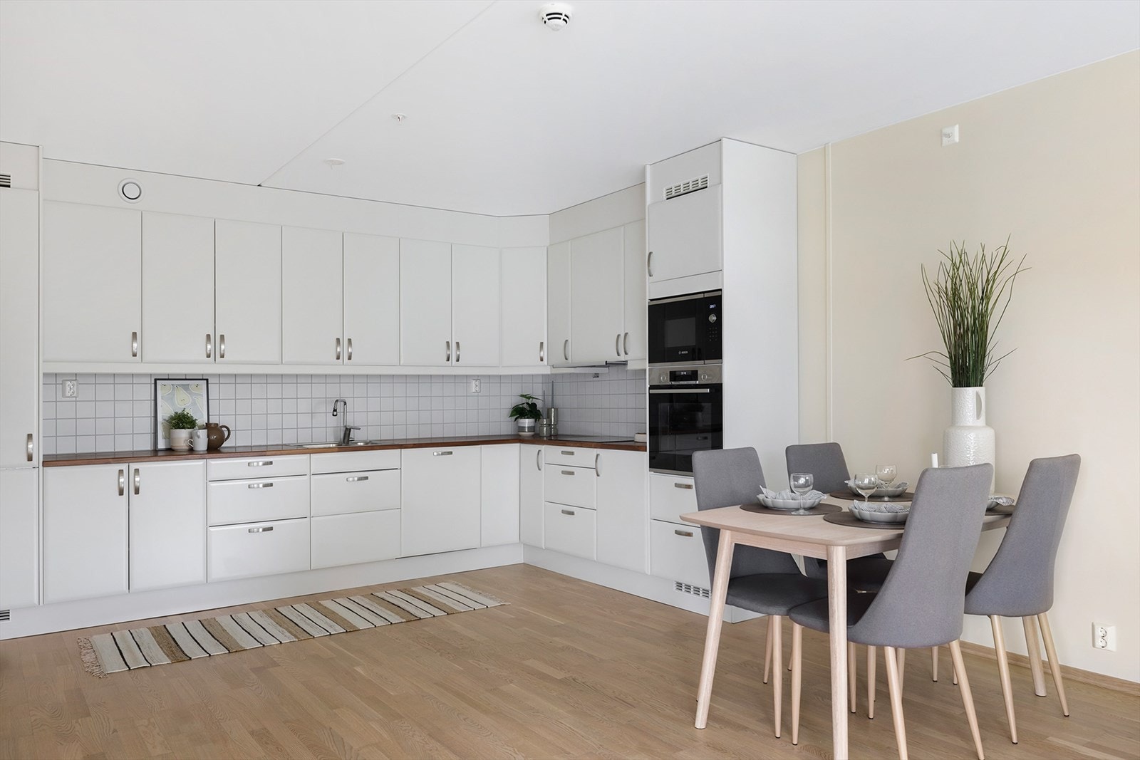 Pent kjøkken med integrerte hvitevarer og rikelig med plass i skap og skuffer Galleribilde