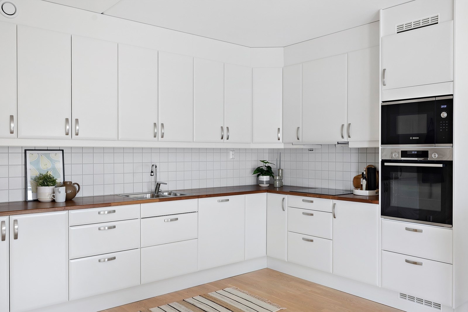 Kjøkken innredning med hvite overflater, og integrerte hvitevarer fra Bosch Galleribilde