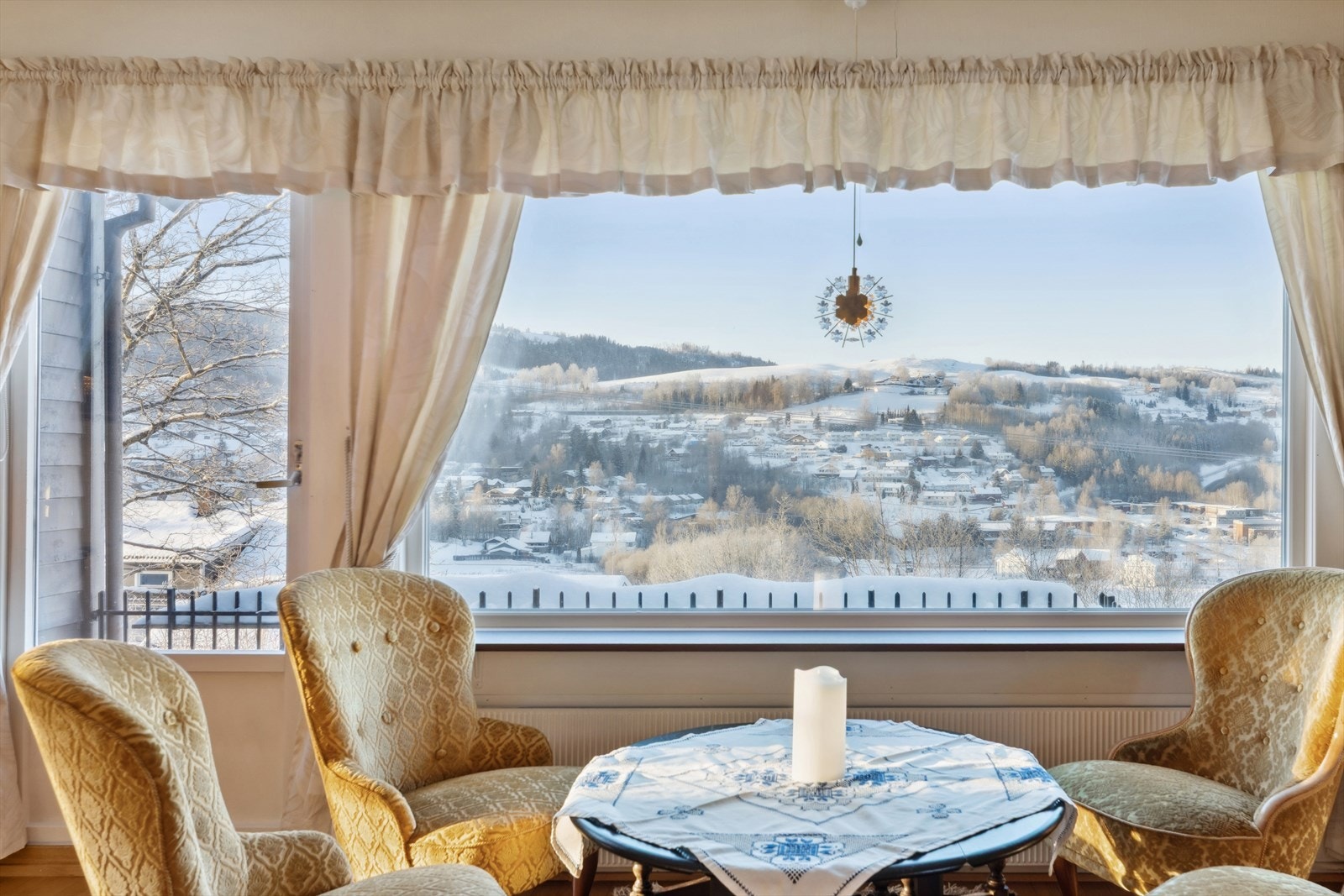 Store vinduer gir panoramautsikt over det vakre landskapet og skaper en lys atmosfære i rommet. Galleribilde