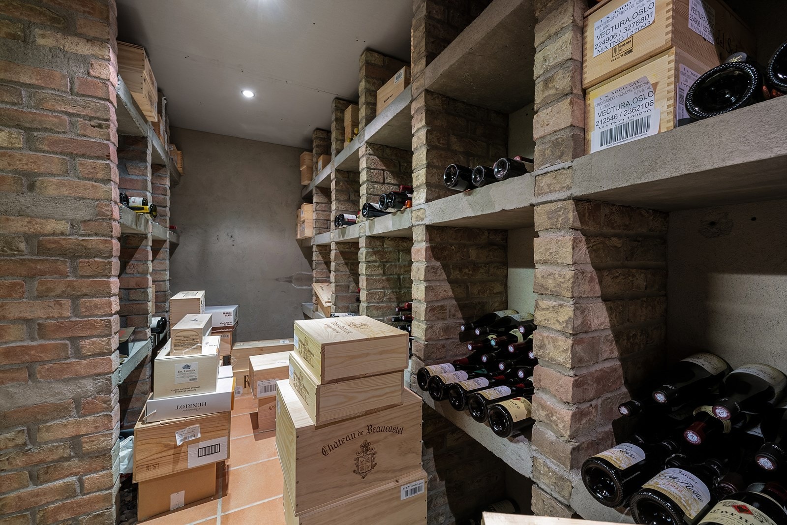 Eget vinrom med støpte hyller i murstein og flislagt gulv - Eget kjøleaggregat gir optimale lagringsforhold Galleribilde