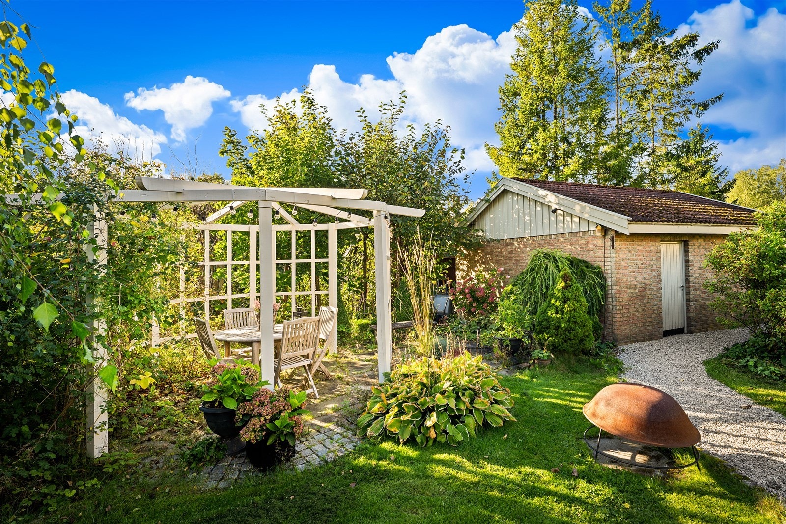 Pent opparbeidet hage med markterrasse og lysthus gir gode uteoppholdsarealer med høy grad av privatliv Galleribilde
