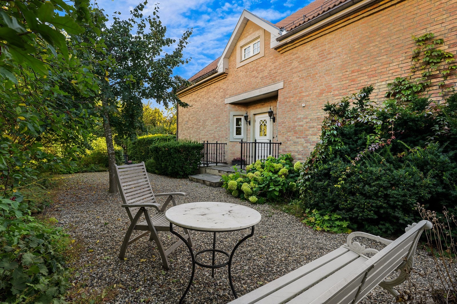 Mot naboeiendom er det avgrensning med levegger i tre samt beplantning med hekk, busker og trær Galleribilde