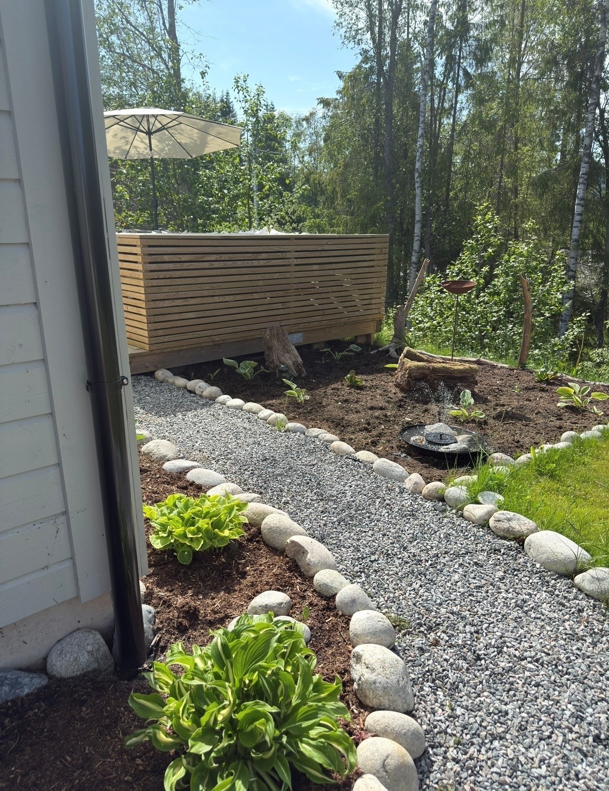 Tomt med plen, beplantning og gruset gangveg. Privat bilde. Galleribilde