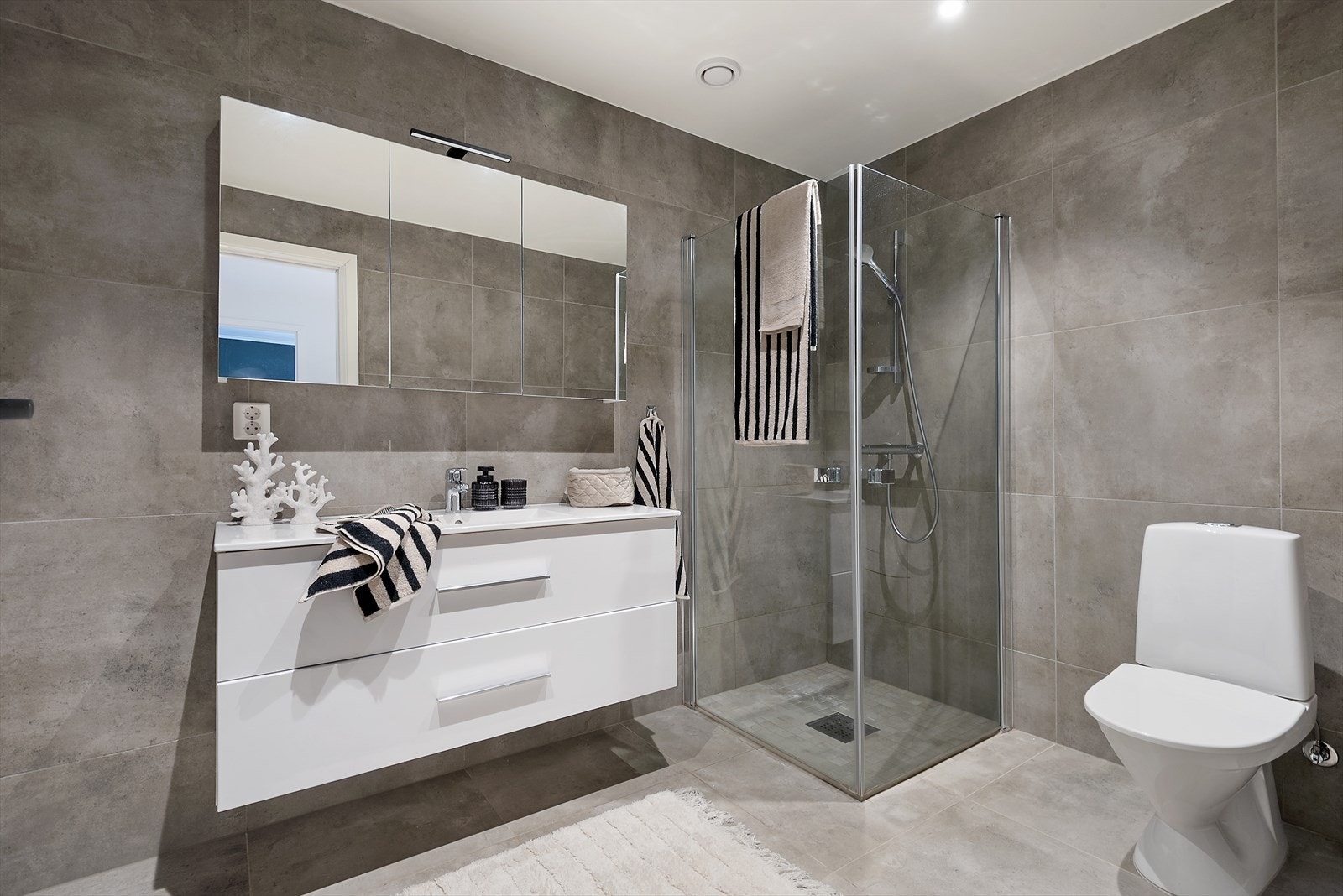 Bad med dusjhjørne og lys innredning. Galleribilde