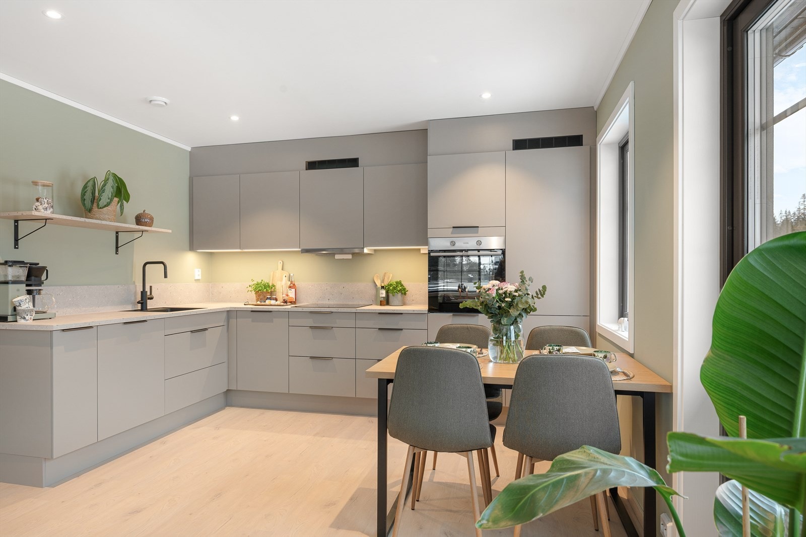 Kjøkkenet har en åpen løsning mot stuen og er innredet med en moderne kjøkkenløsning med brunbeige, slette fronter og laminert benkeplate med underlimt benkbeslag samt ett-greps blandebatteri. Galleribilde