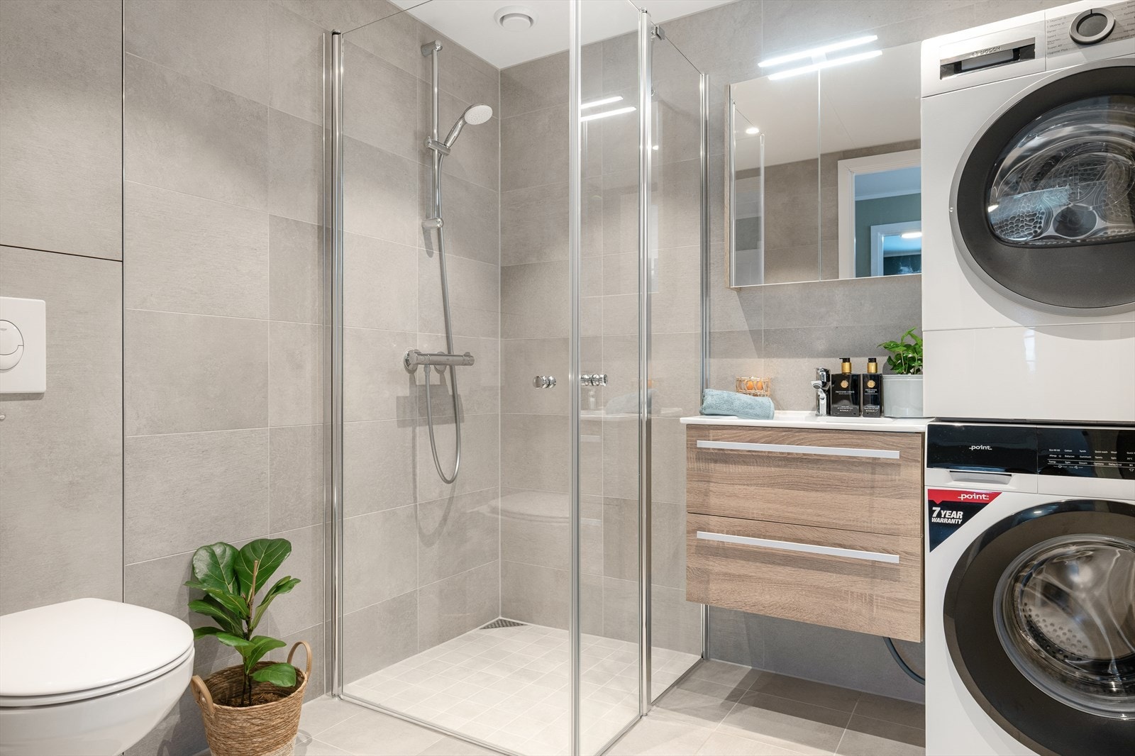 Lekkert og tidløst bad fra byggeåret med flislagte overflater og komfortable varmekabler i gulvet. Galleribilde