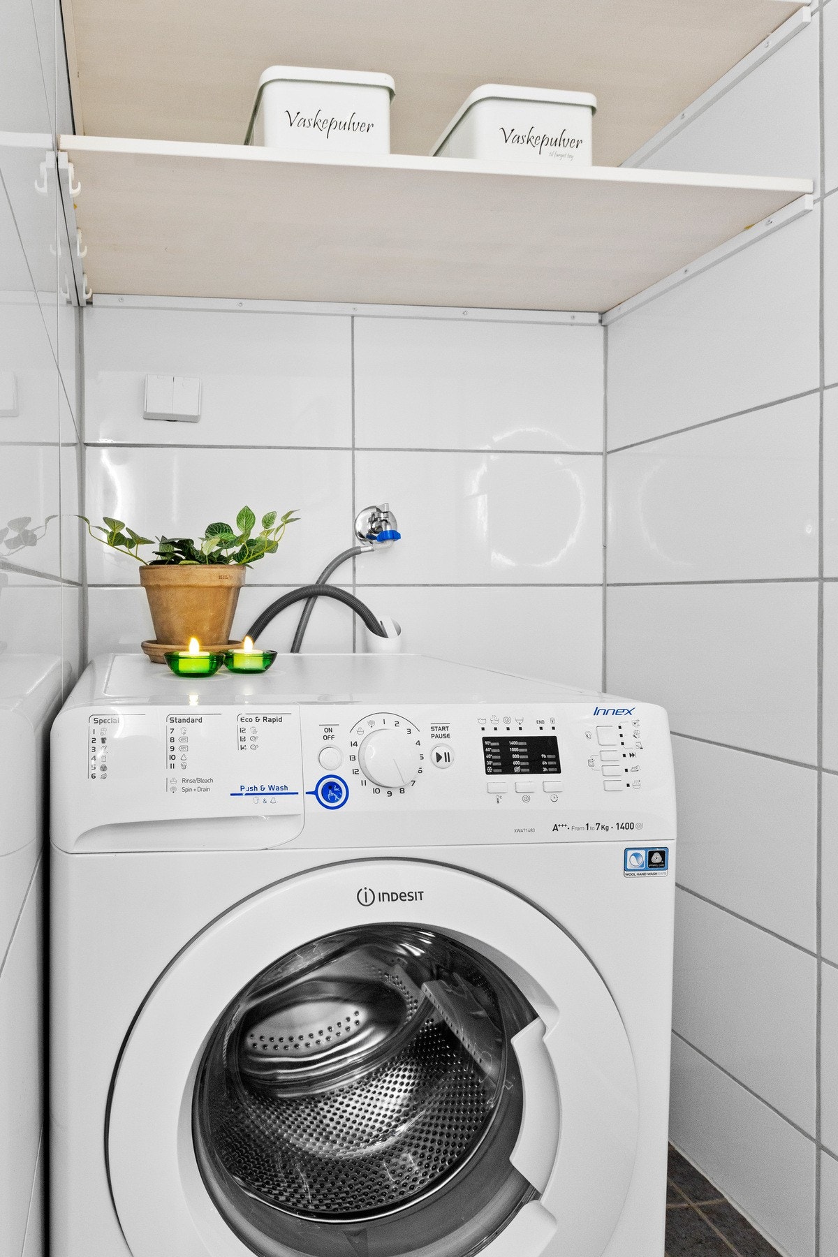 Her er det plass til vaskemaskin i en tilbaketrukket nisje, slik at rommet oppleves ryddig og effektivt. Galleribilde