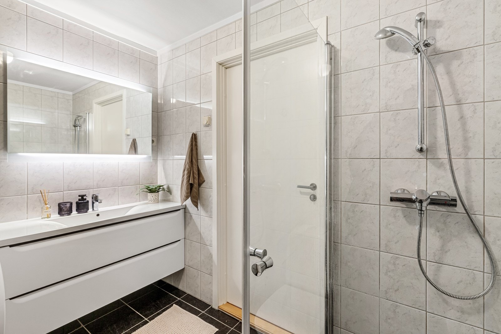 Nyere, moderne innredning og speil med lys. God plass til ekstra skap/hyller på badet. Moderne dusjhjørne med glassdører. Galleribilde