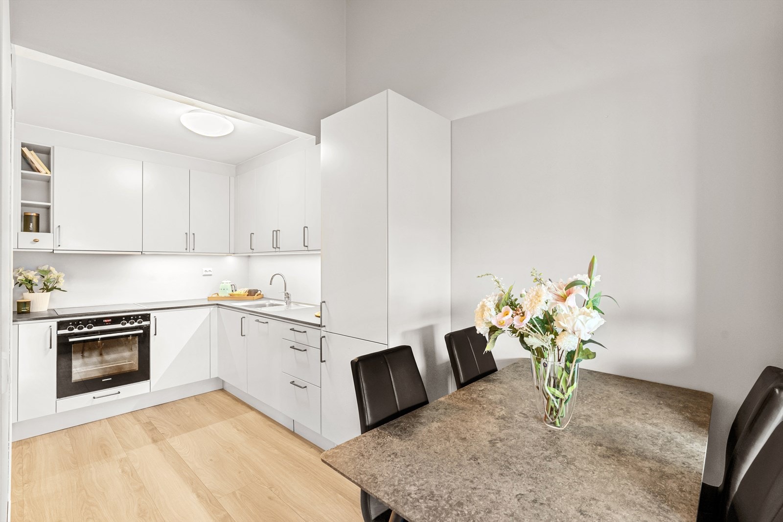 Det nyere Drømmekjøkkenet er moderne og tidløst i hvitt. Plass til eget spisebord også her - gir flere muligheter for møblering i stuen. Galleribilde