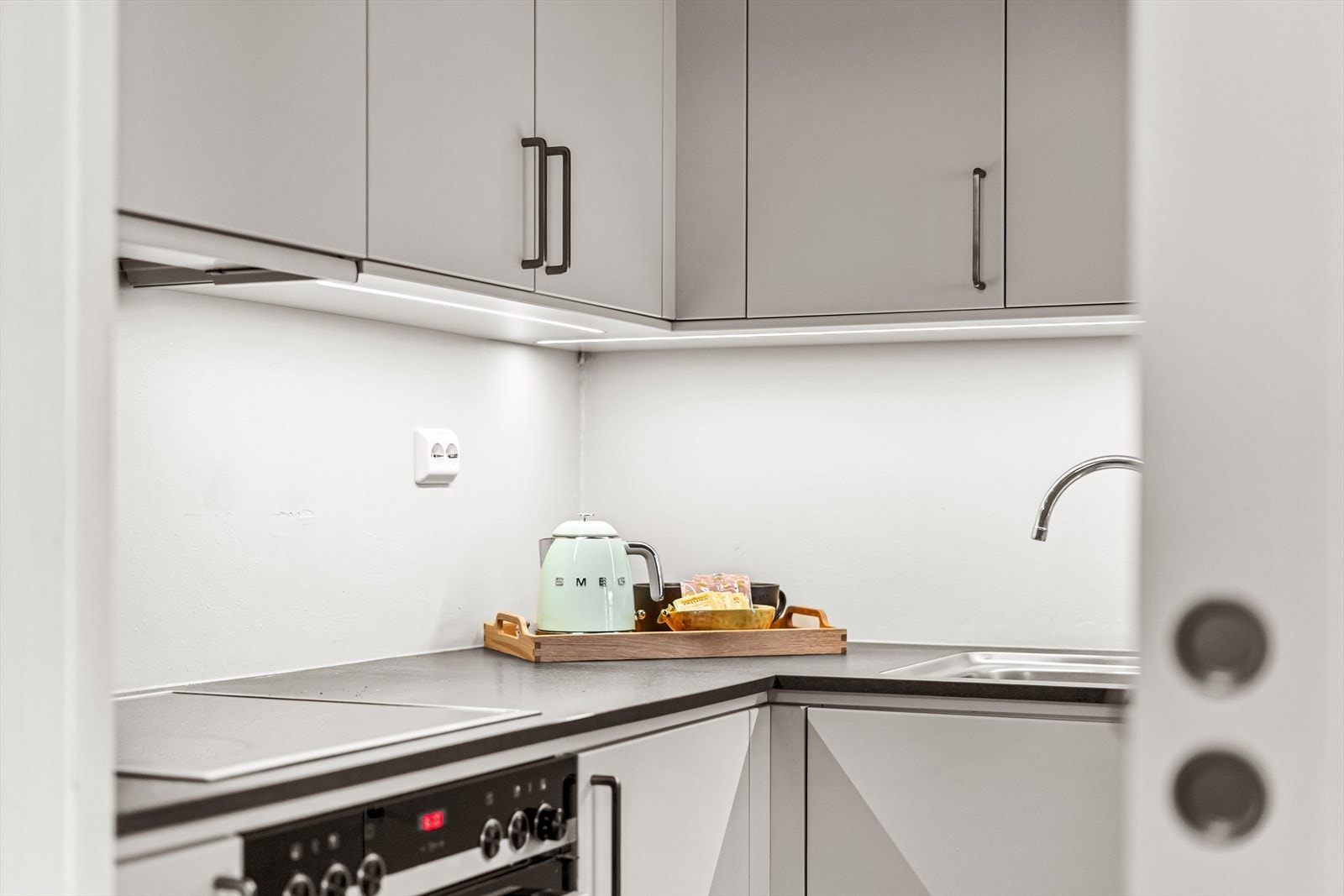 God led belysning over arbeidsbenk. Smart plasserte stikk for kjøkkenmaskiner. Det nyere kjøkkenet innbyr til bruk og kan lukkes av med skyvedør mot stuen. Galleribilde