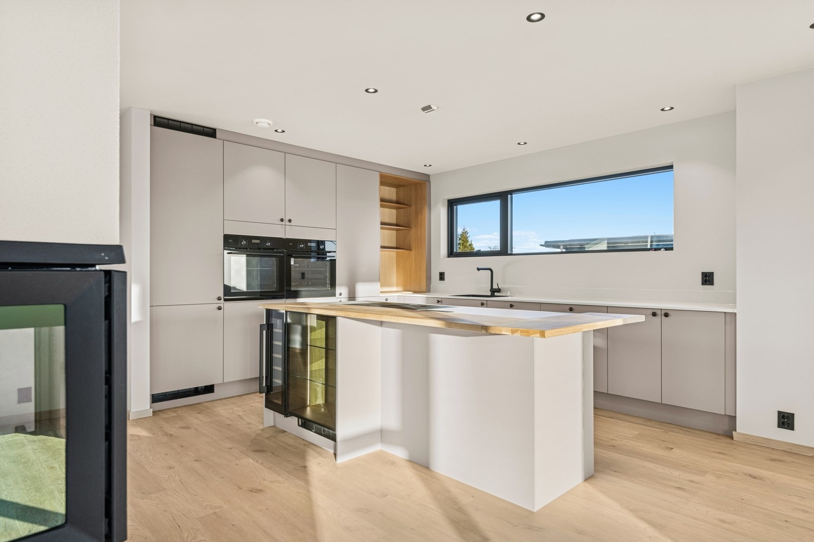 Kjøkken med nydelig beige farge og med sosial kjøkkenøy Galleribilde