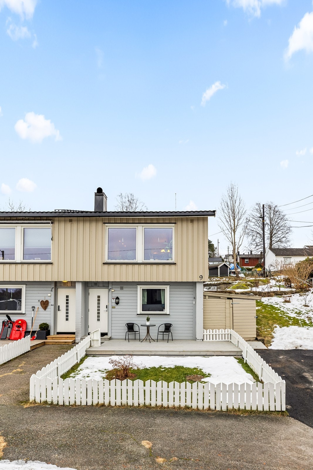 Eiendommen har en lettstelt forhage med platting og et lite, hvitt stakittgjerde. Galleribilde