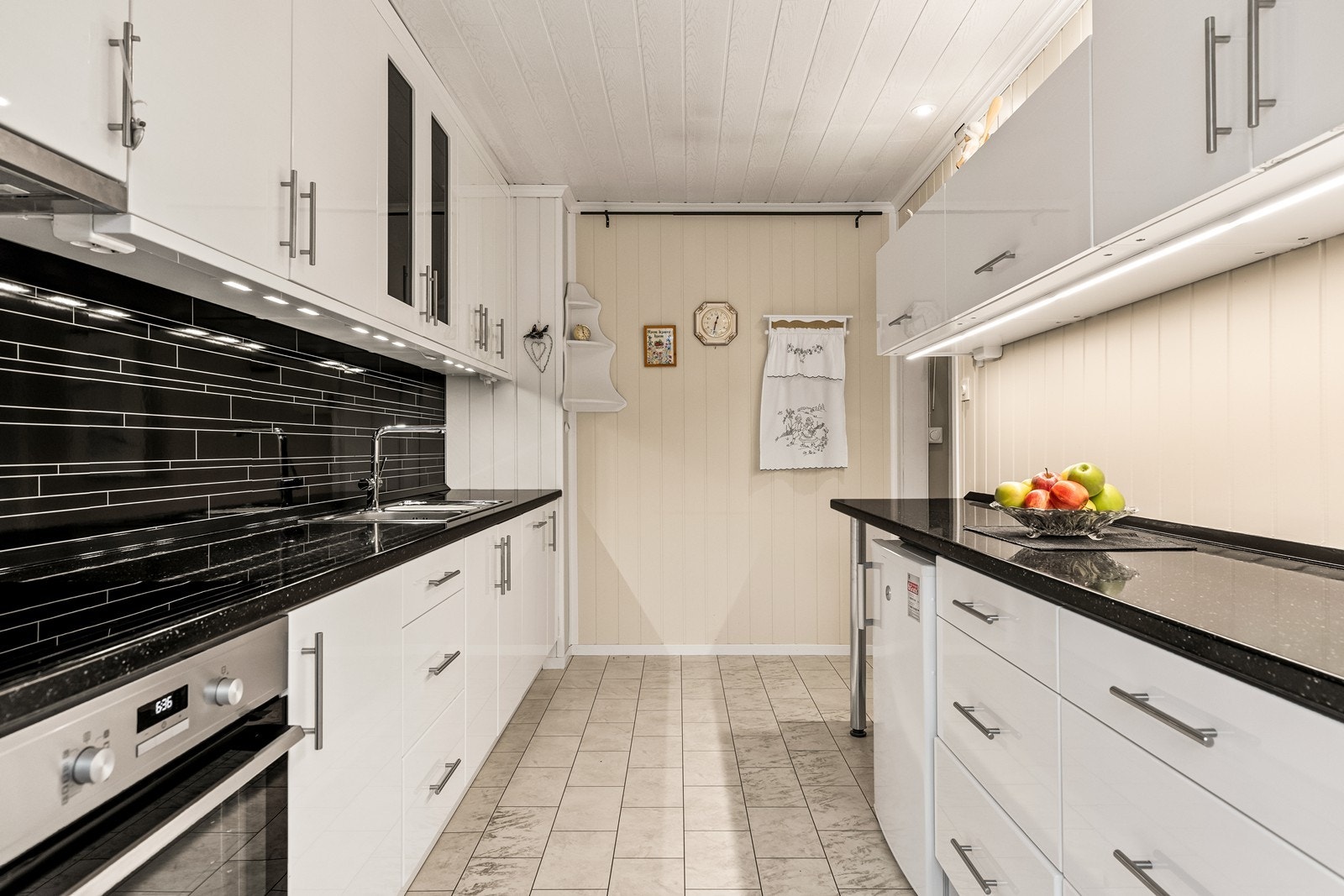 Innredningen har tidløse, hvite fronter, mørk benkeplate og godt med arbeidslys. Galleribilde