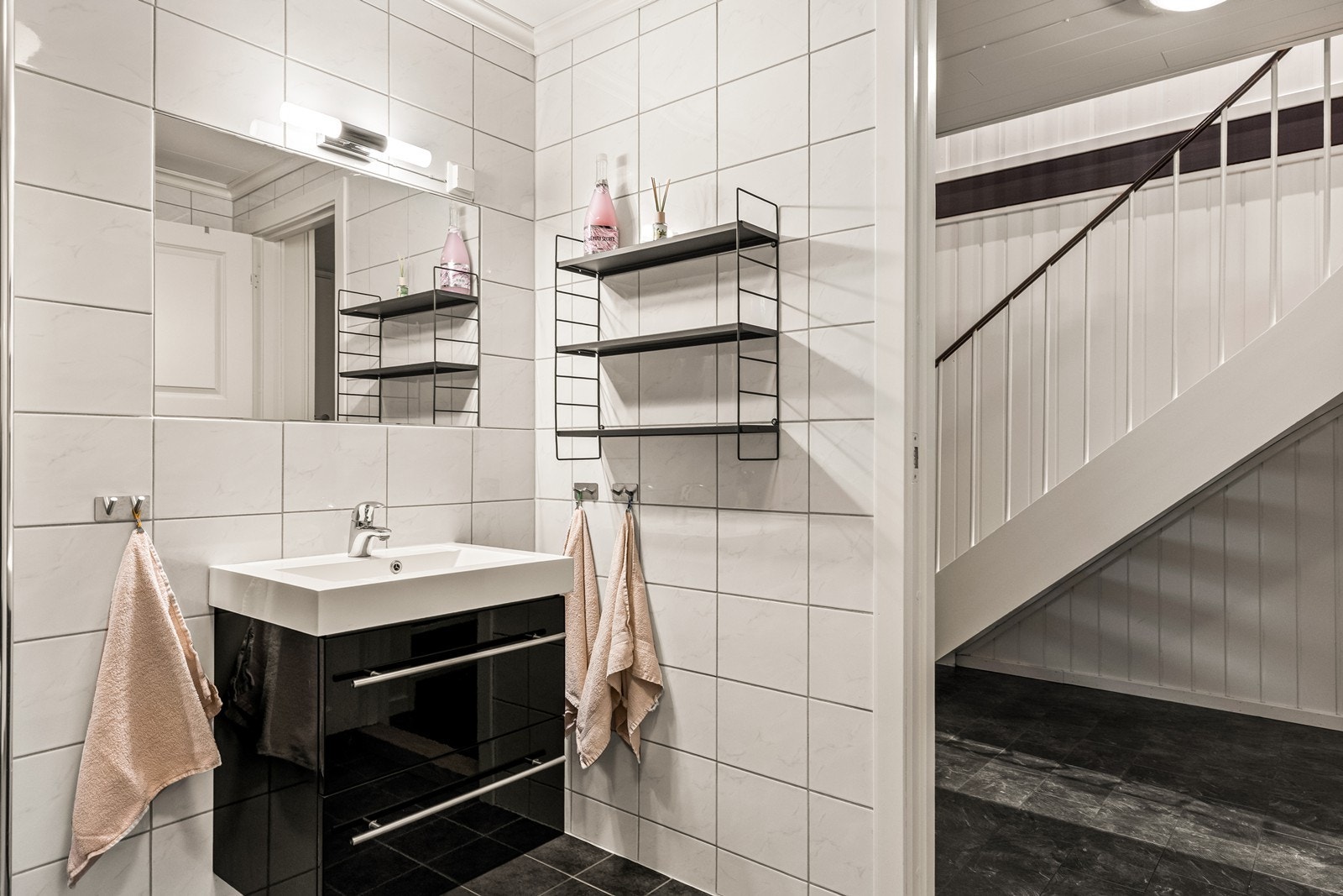 Helfliset bad med servantinnredning, speil med belysning og vegghengt toalett. Galleribilde