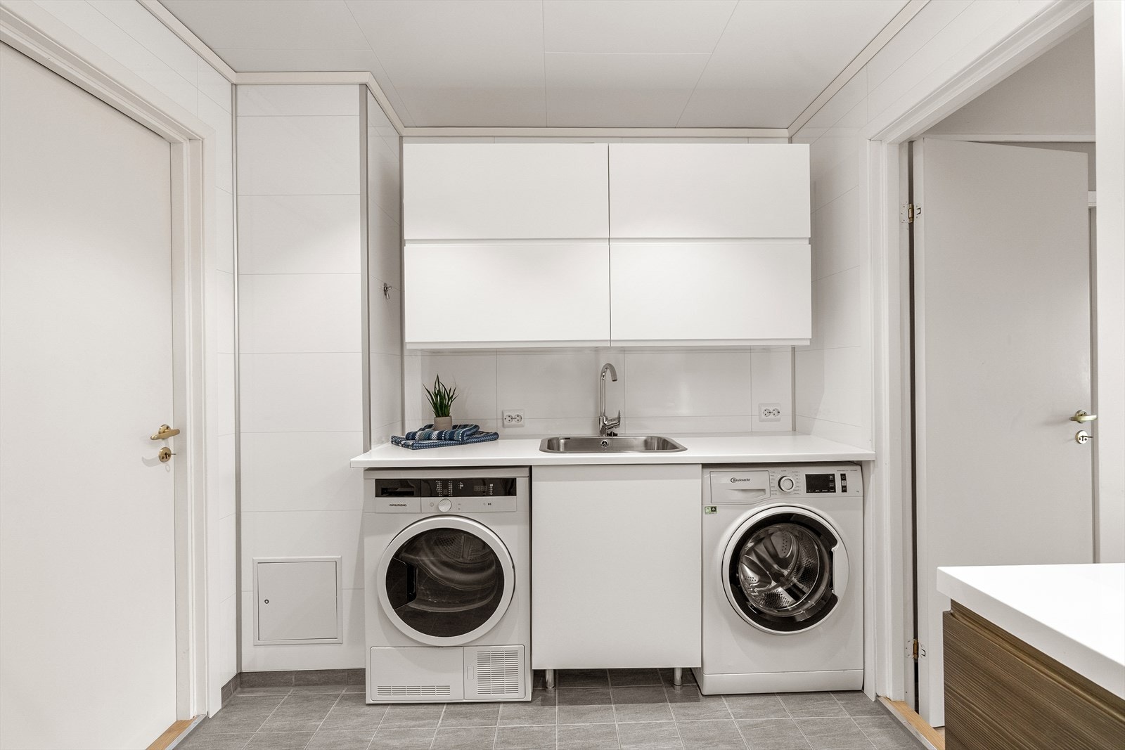 Badet har også en praktisk innredning med vaskemaskin, lagring og utslagsvask. Galleribilde