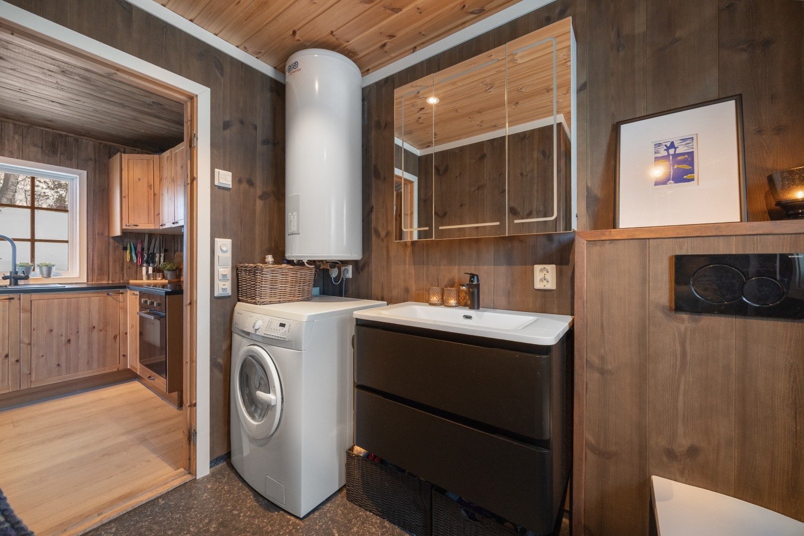 Varmtvannstanken er plassert på veggen, og det er opplegg for vaskemaskin på badet. Galleribilde