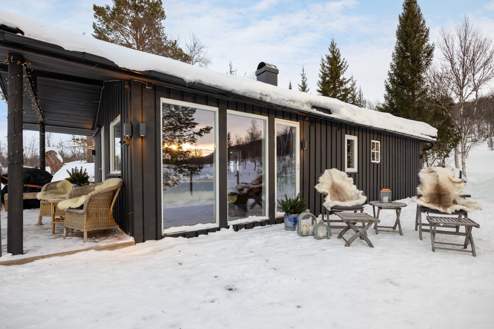 Store vindusflater gir godt utsyn fra stuen, og det er sittegruppe plassert utenfor. Galleribilde