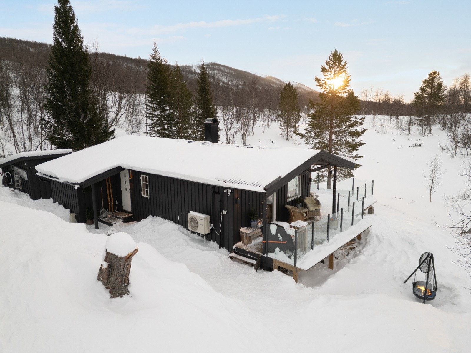 Boligen har saltak tekket med stålplater, og det er montert en varmepumpe på veggen. Galleribilde
