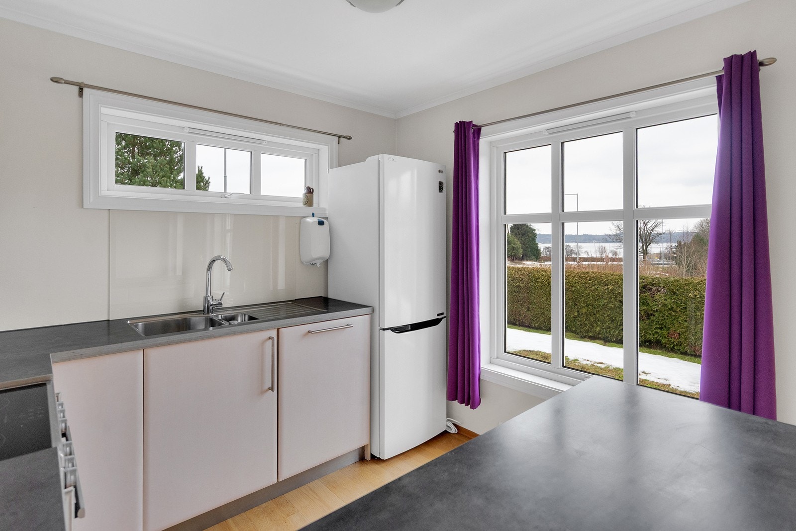 Store vinduer slipper inn mye naturlig lys og skaper en luftig atmosfære. Galleribilde