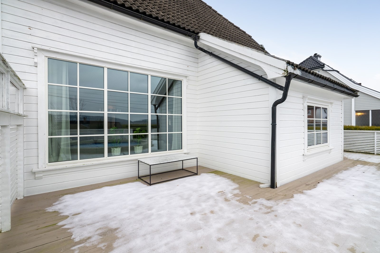 Terrassen har rekkverk rundt på alle sider, og trapp med rekkverk ned til hagen. Galleribilde